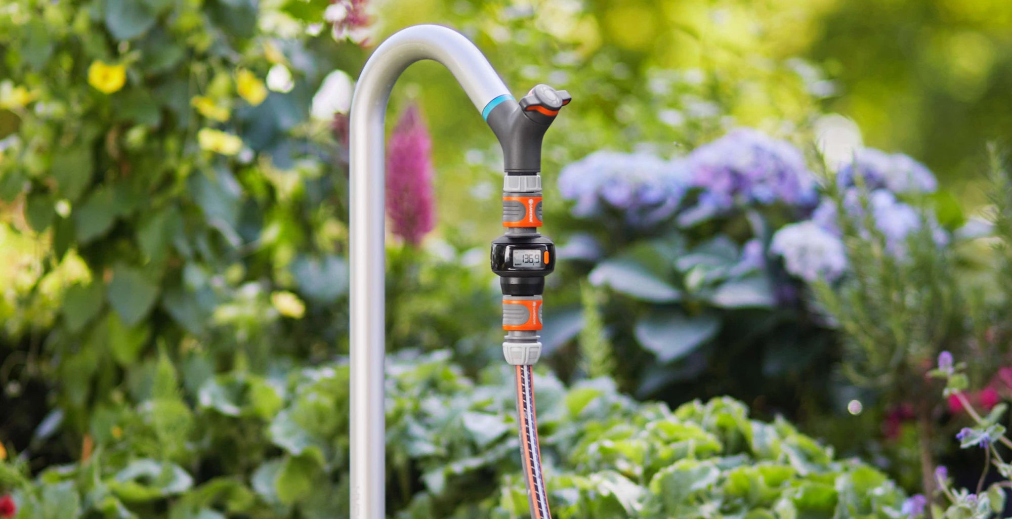 Garden hose with spray nozzle against a garden background